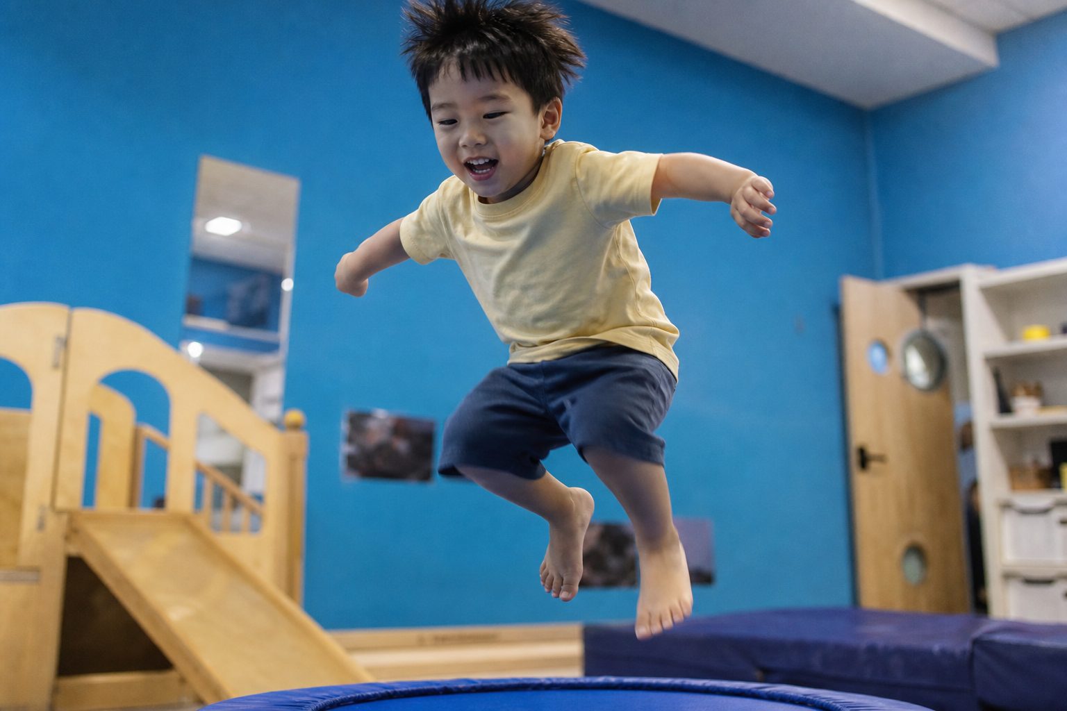 Child mid jump against a bright blue background
