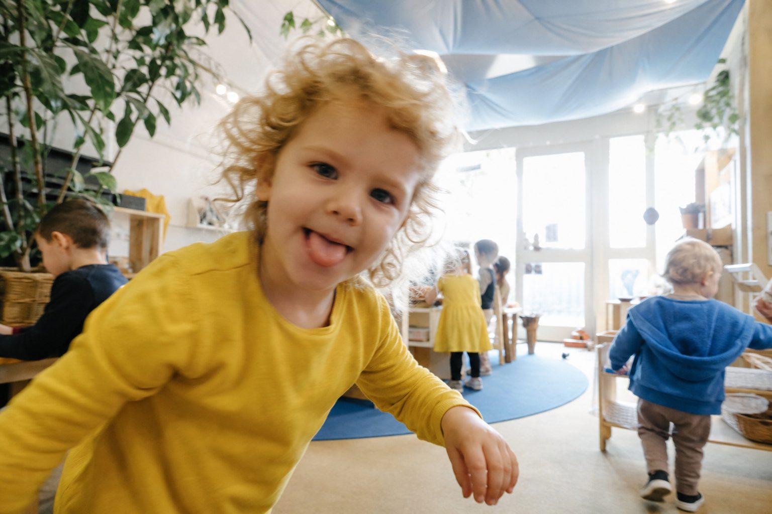 Photographer working in the corner of a busy bright childcare room