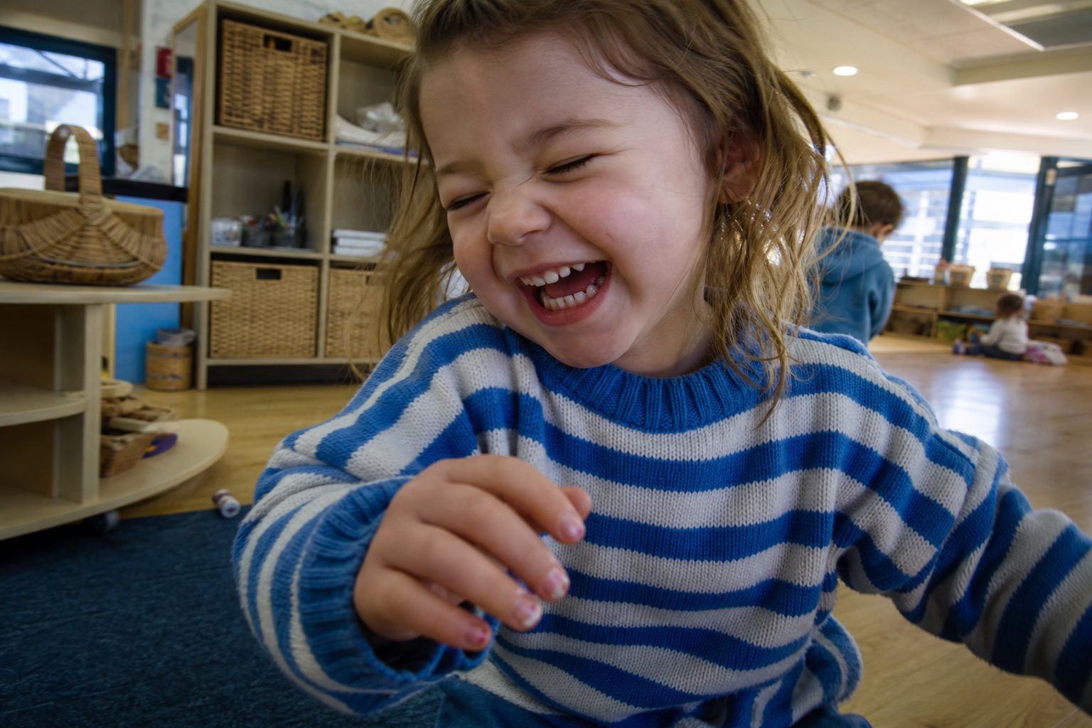 Child mid-laugh with eyes closed