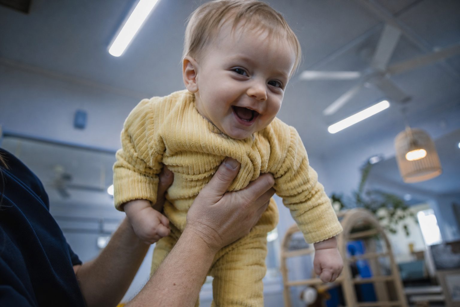 Baby mid-giggle being held up