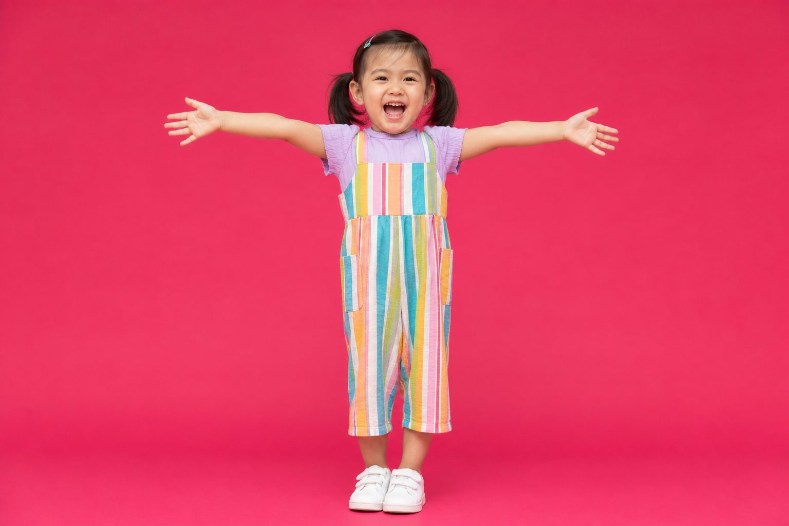 A wall of vivid coloured paper backdrop rolls in a bright studio