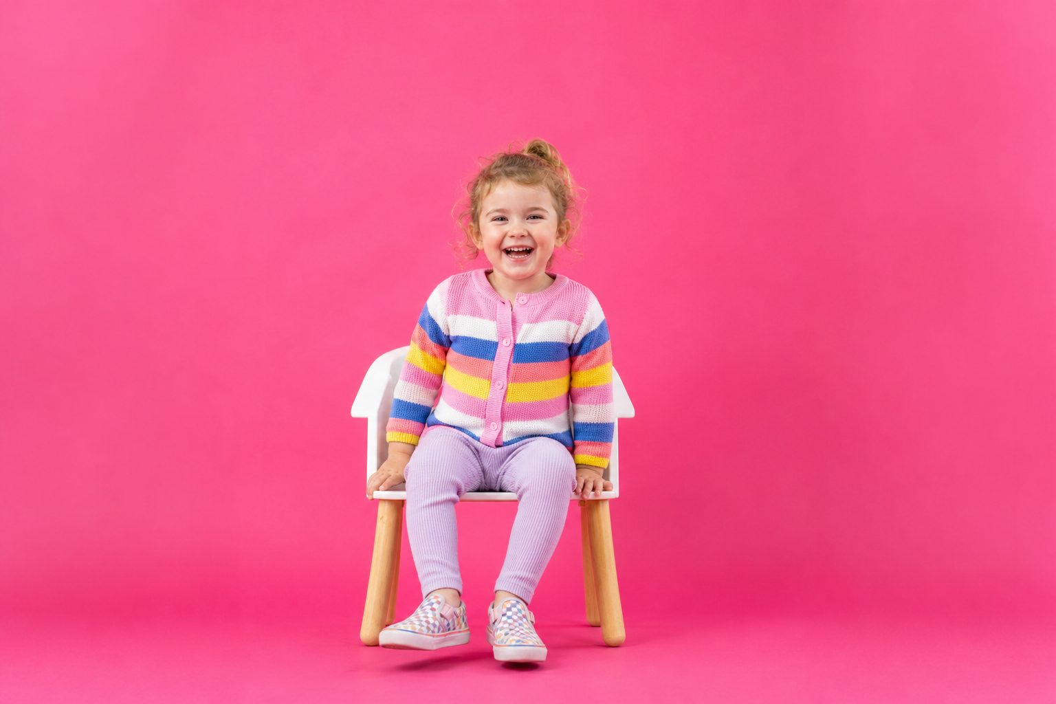 Photographer taping a bright coloured backdrop to a childcare room wall